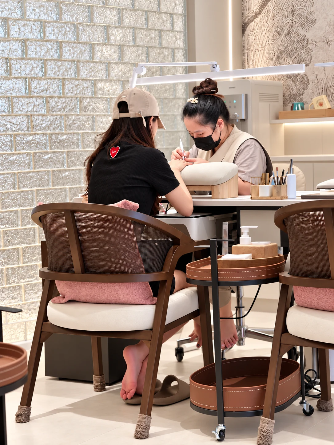 A Tutuunails artist working carefully on a client's nails at a manicure station